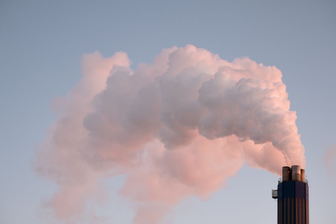 Chimeneas industriales emitiendo humo, que ilustran la importancia del monitoreo de emisiones