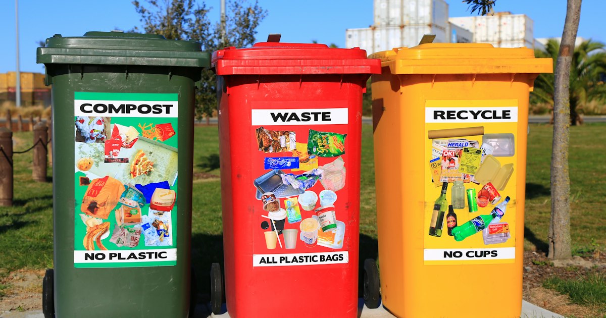 Contenedores de reciclaje de colores para separación de residuos en un entorno industrial